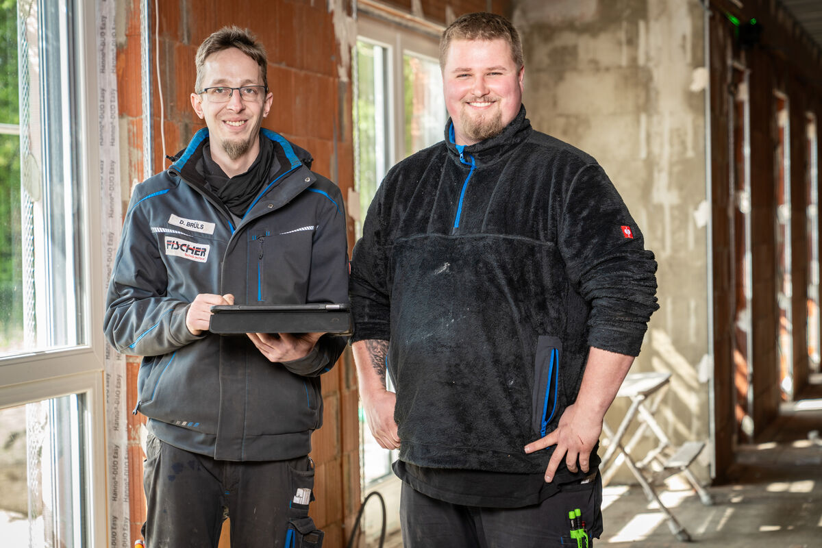 Zwei Kollegen auf einer Baustelle im Rohbau
